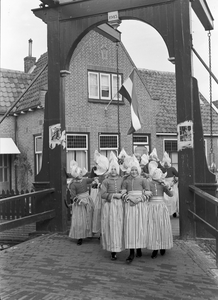 836428 Afbeelding van een groep meisjes in klederdracht op een bruggetje te Volendam.